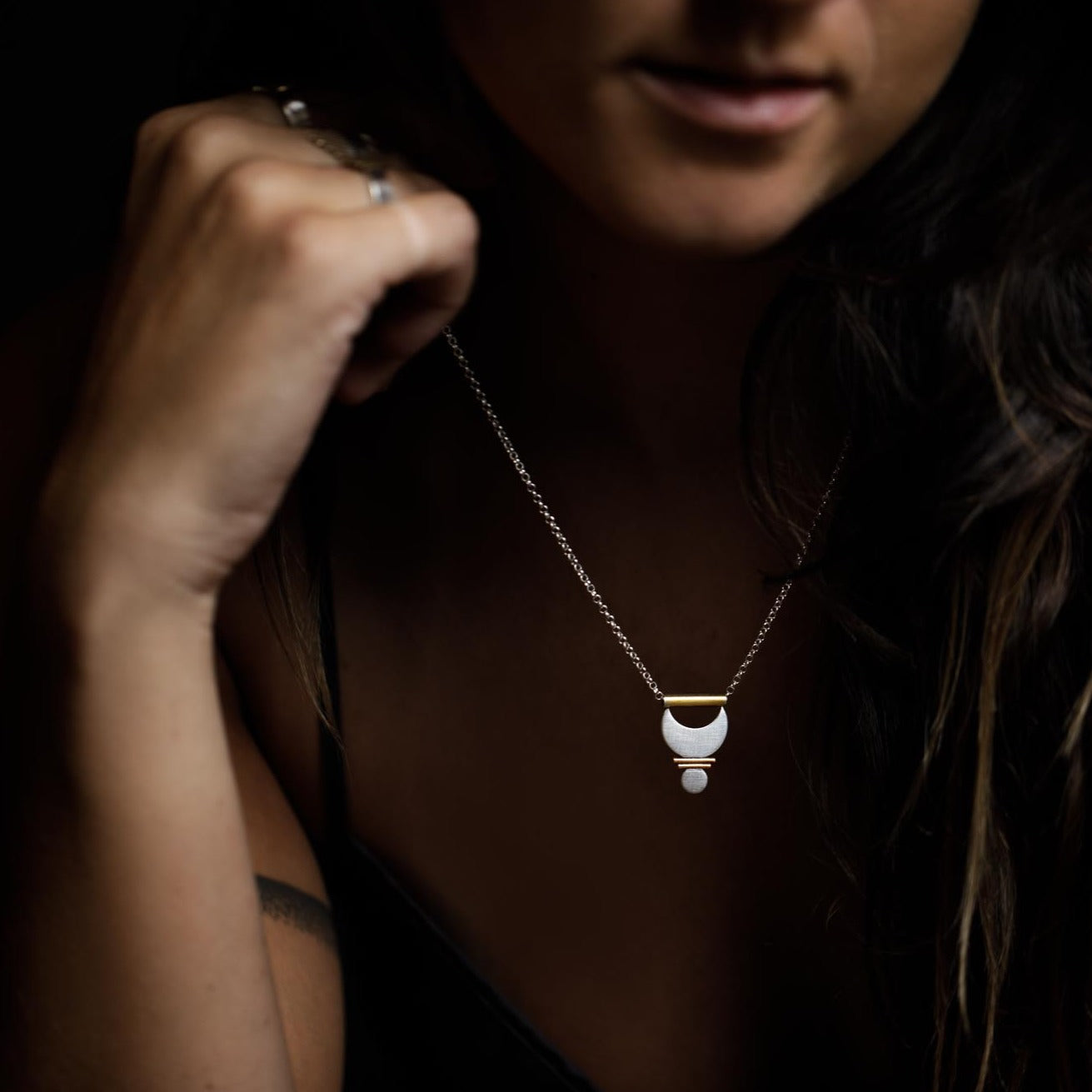 A close up of the Small Prana Pendant to show off its mixed metal and textural details.