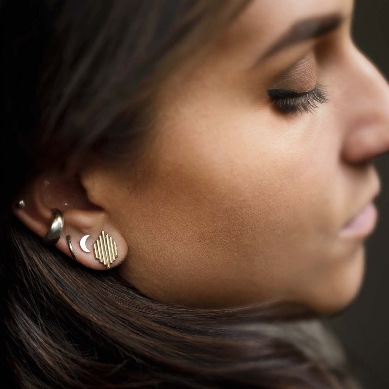The Shiva Studs worn alongside the small crescent moon studs to mix symbols of the divine feminine and the divine masculine.