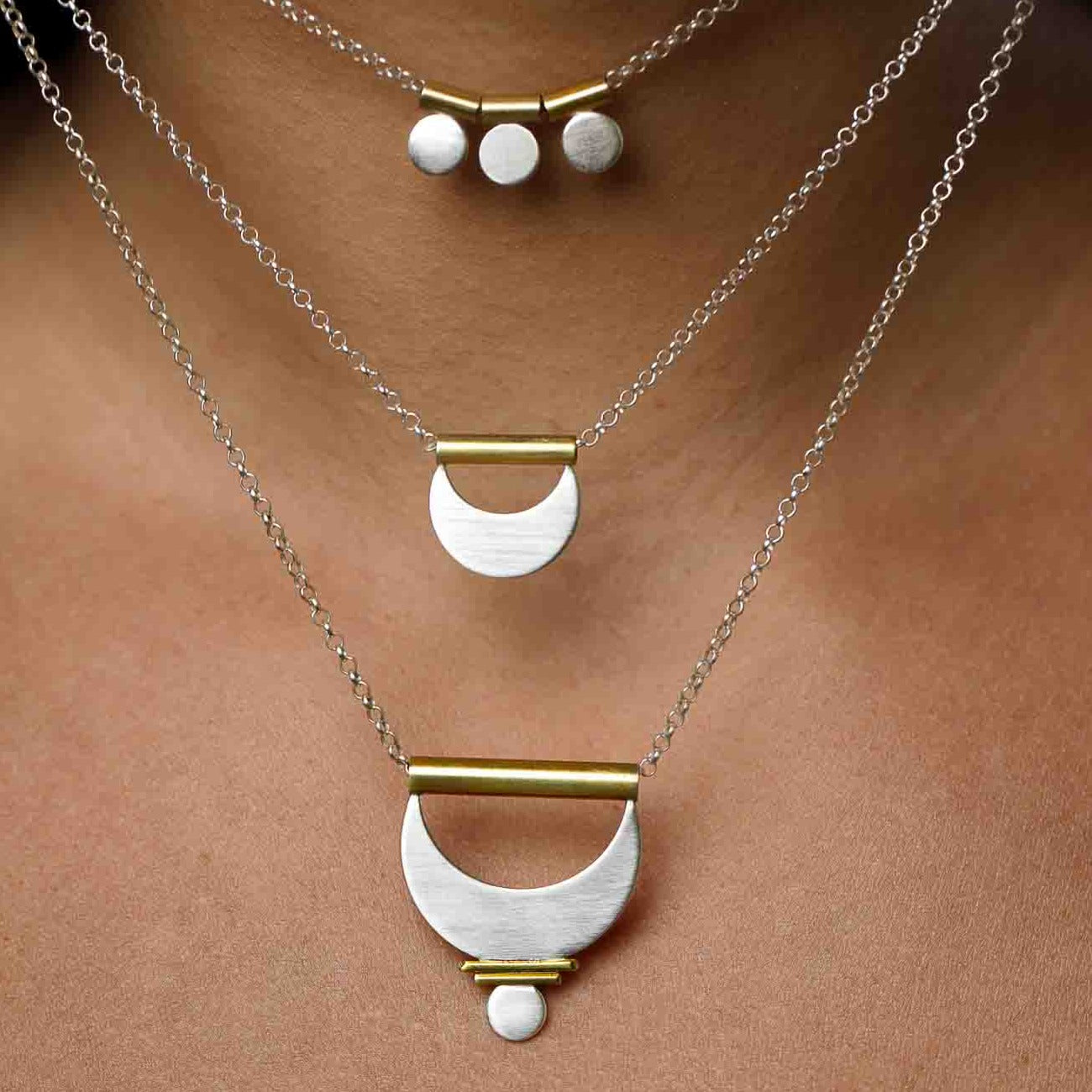 Three mixed metal layering necklaces shown close up to admire the geometry and craftsmanship.