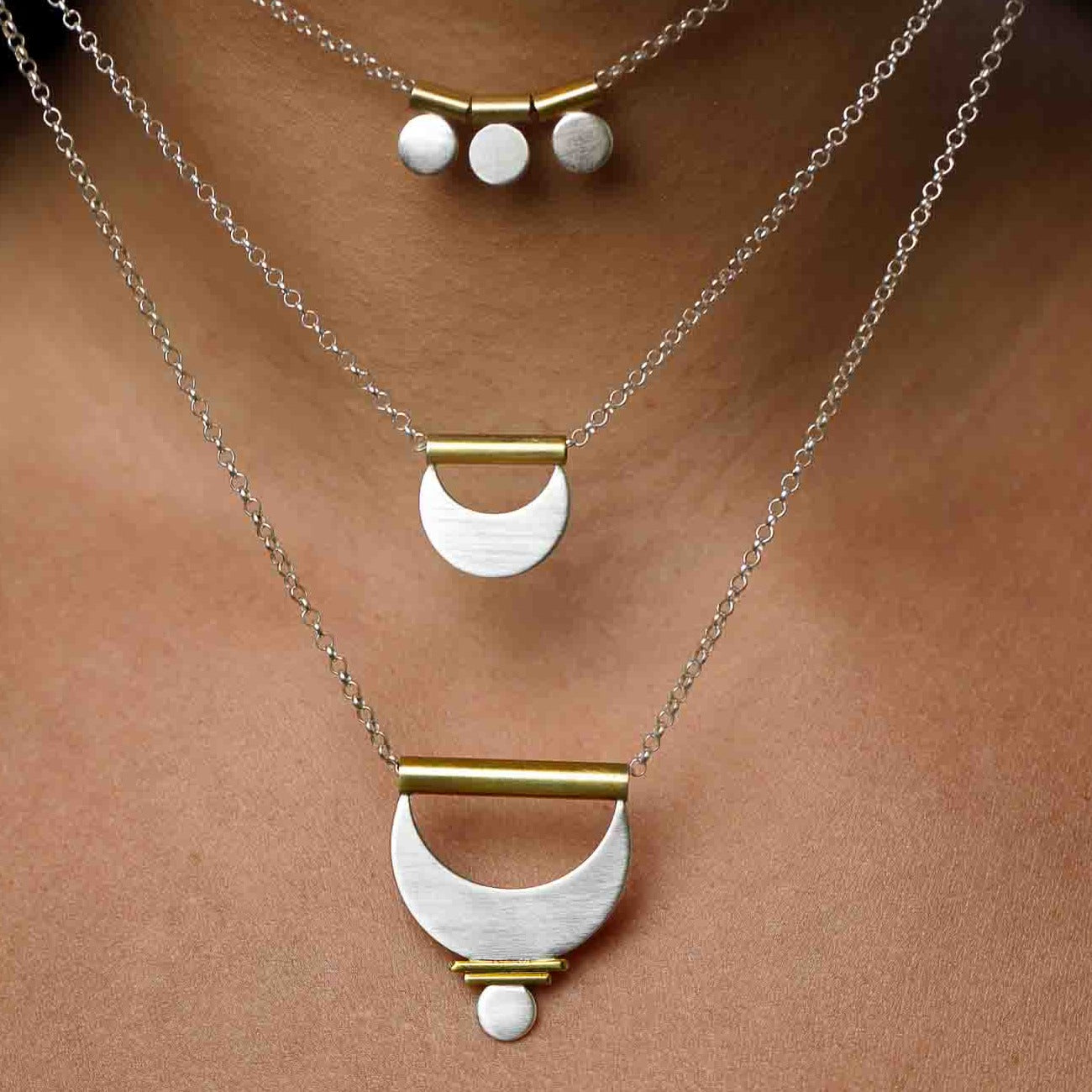 The Shatki Pendant, the Crescent Moon Pendant, and the Large Prana Pendant shown layered together for a feminine mixed metal look.