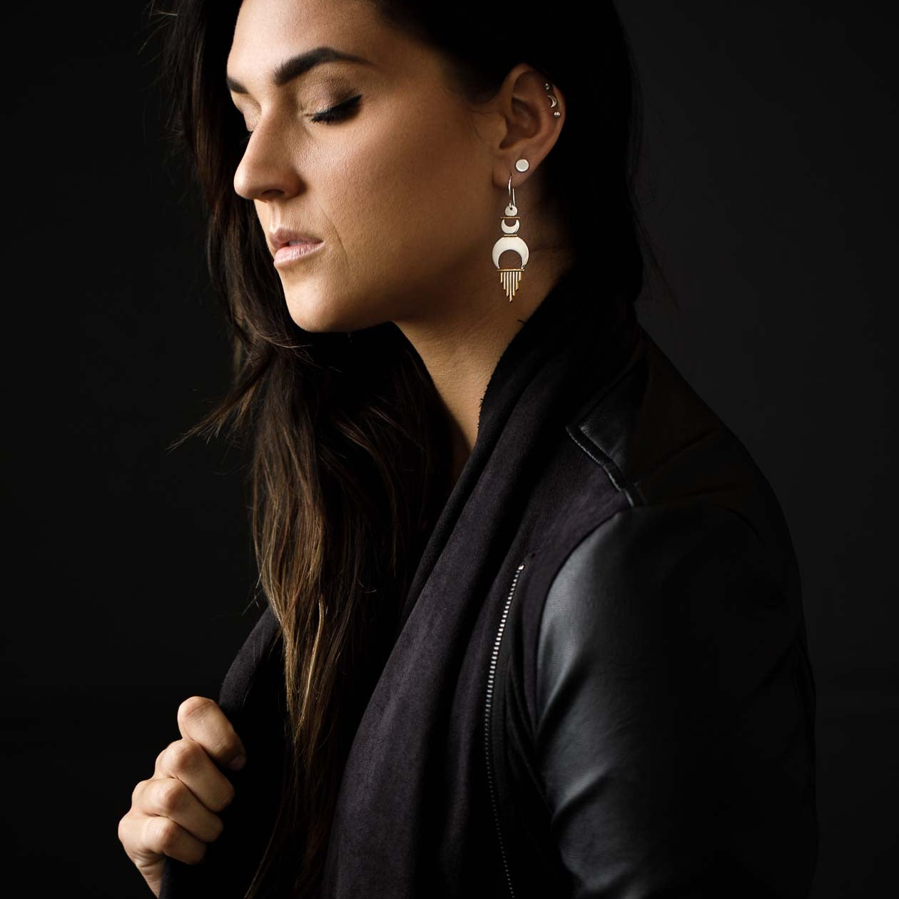 Model feels strong and empowered while wearing her Alchemy Earrings styled with a black leather jacket