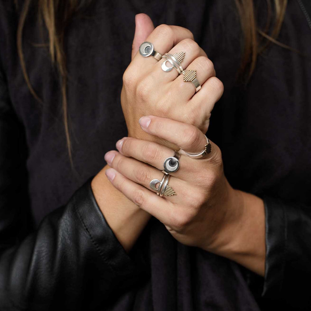 
                  
                    Fists full of mixed metal rings show confidence and strength in a powerful pose. 
                  
                