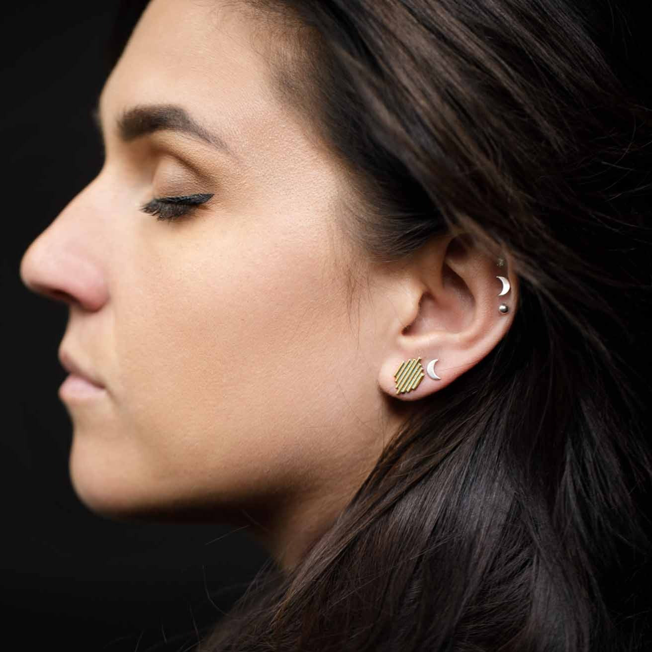 Wearing a mix of sun and moon symbol stud earrings to balance the masculine and feminine.