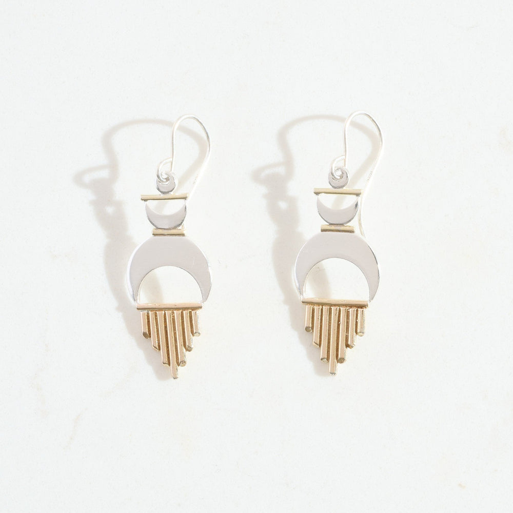 
                      
                        Pair of earrings with silver moon shapes and gold sun rays on a white background
                      
                    