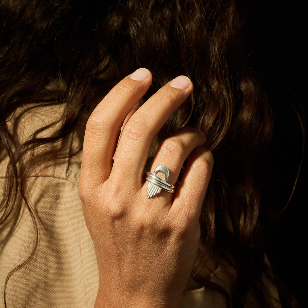 Hand with a silver ring on a dark background