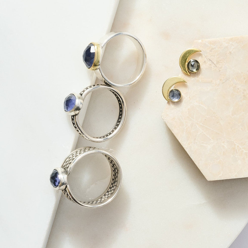 
                      
                        Silver jewelry set with gemstones on a white surface
                      
                    