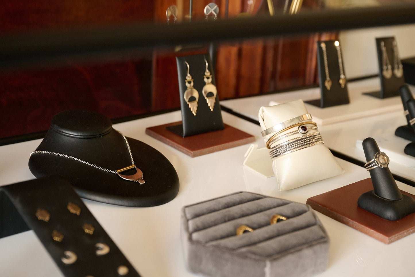 Jewelry display with rings, bracelets, and earrings on a white surface.
