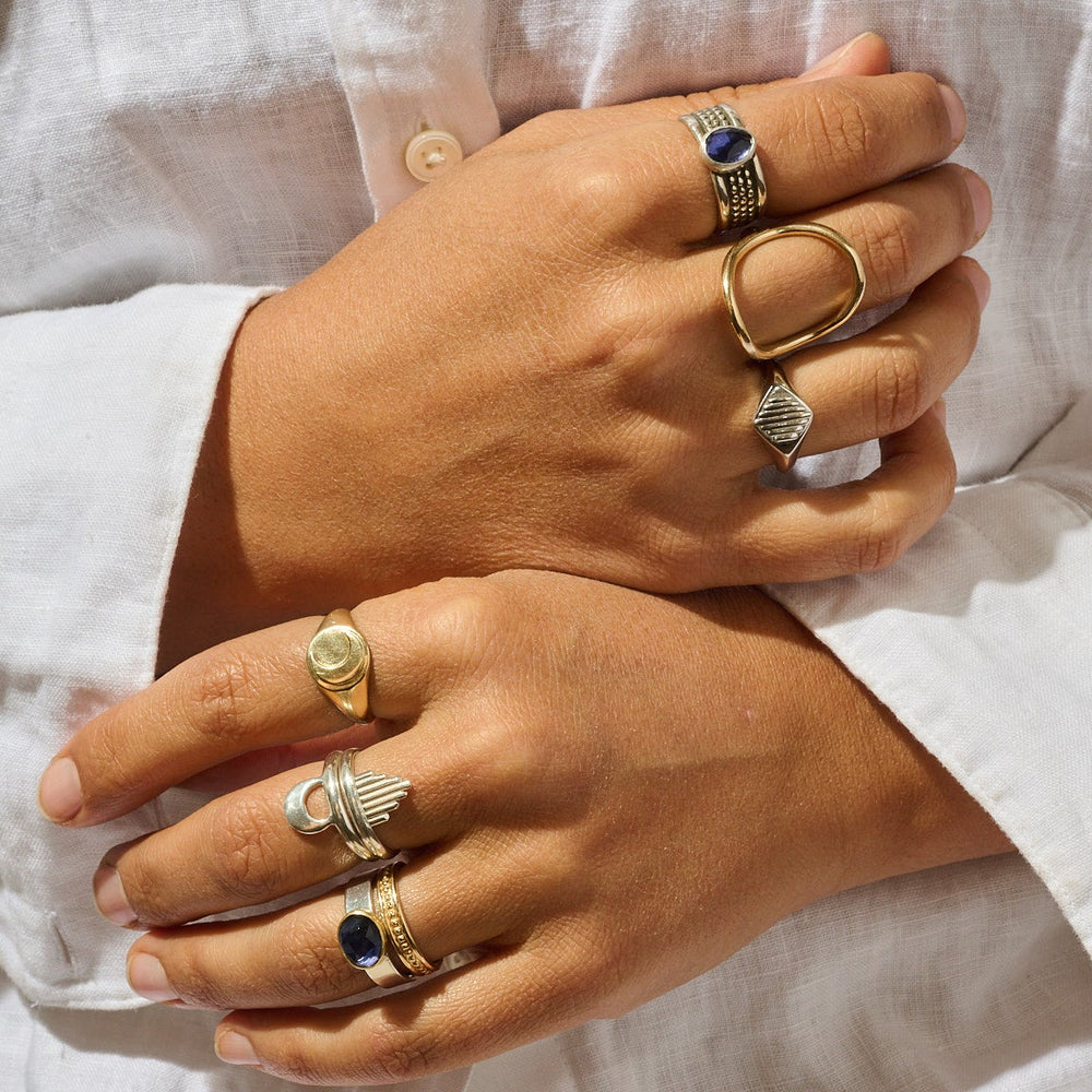 
                      
                        Close-up of hands wearing multiple rings with a blurred background
                      
                    