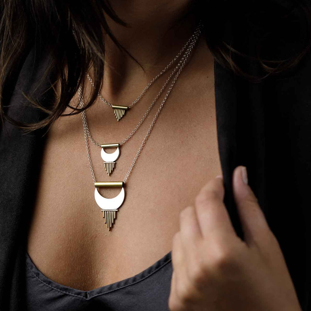
                  
                    Three layering necklaces from the Alchemy Collection with moon shapes and stylized sun ray symbols bring empowerment to the wearer. 
                  
                