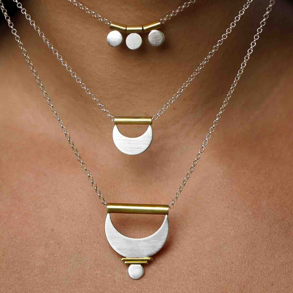 
                  
                    The Shatki Pendant, the Crescent Moon Pendant, and the Large Prana Pendant shown layered together for a feminine mixed metal look. 
                  
                