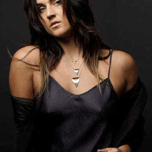 
                  
                    The Small and Large Alchemy Pendants layered with the Sun Ray Pendant styled with a dark purple silk dress and a black jacket. 
                  
                