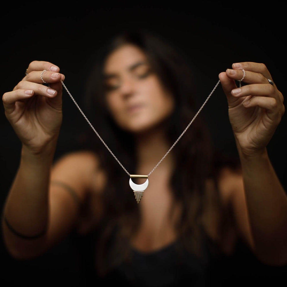 
                      
                        Model holding up the Large Alchemy Pendant for us to see its details and delicate silver chain. 
                      
                    